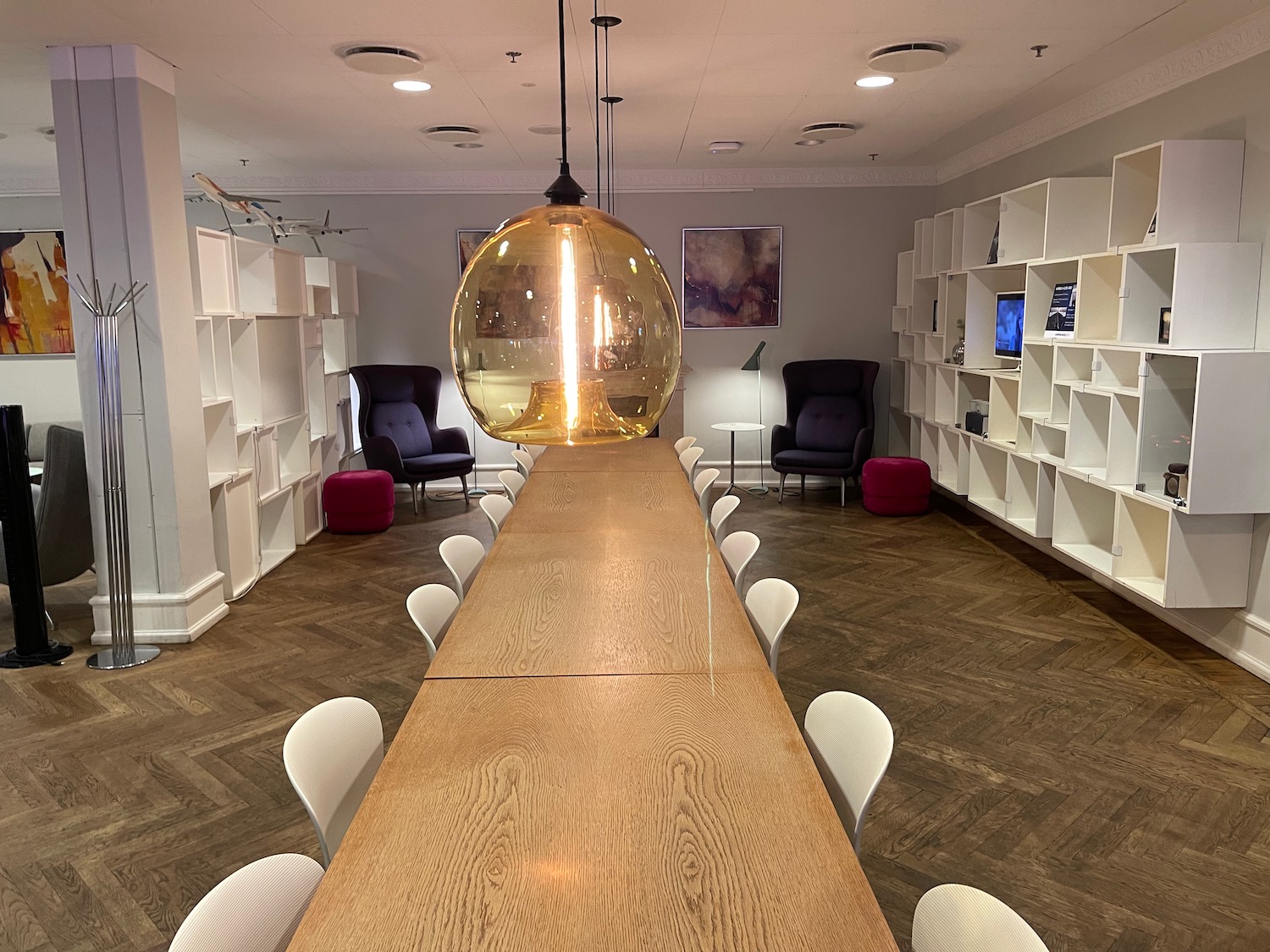 a long table with chairs and a large globe from the ceiling