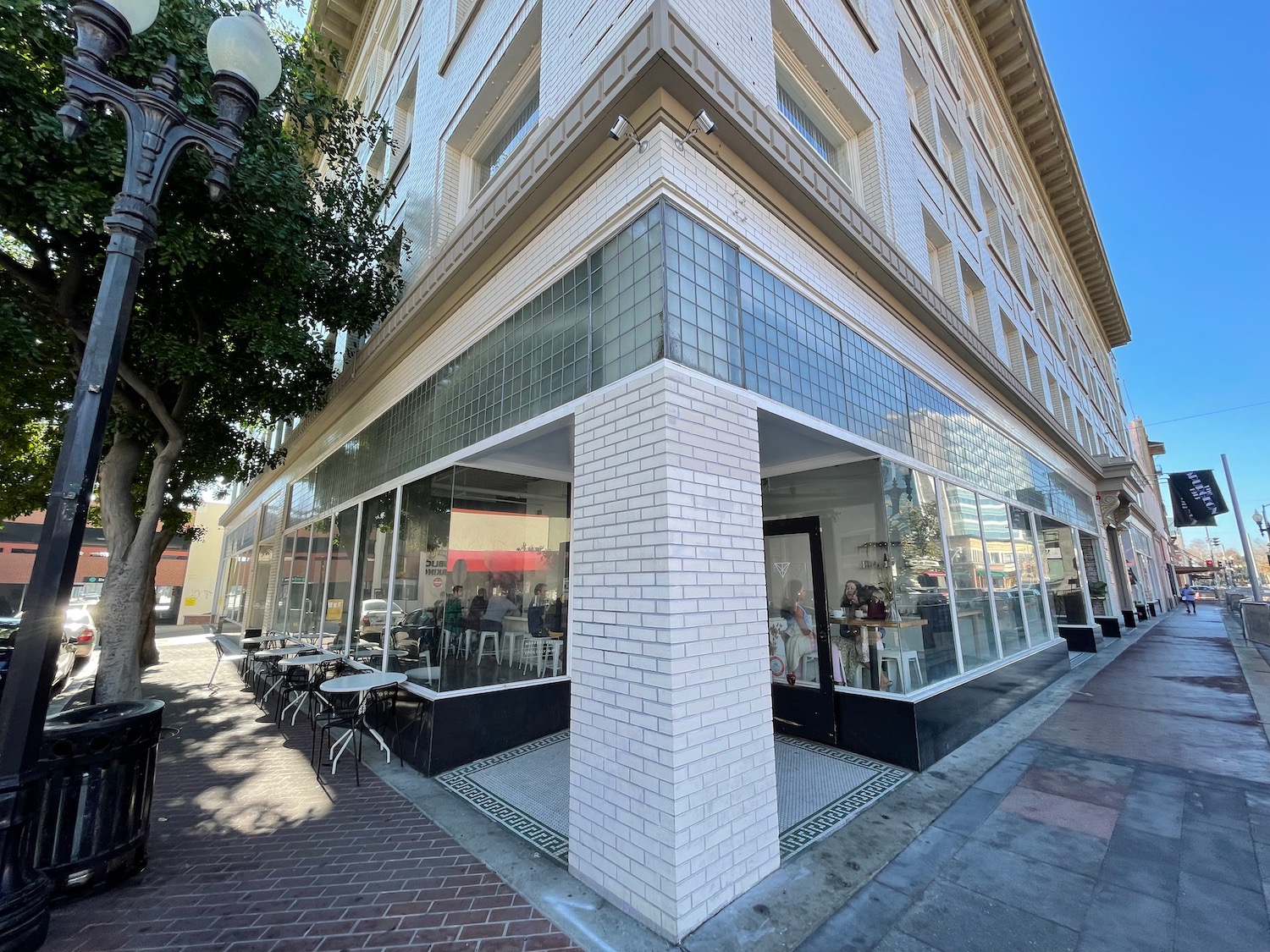 a building with glass windows and tables outside