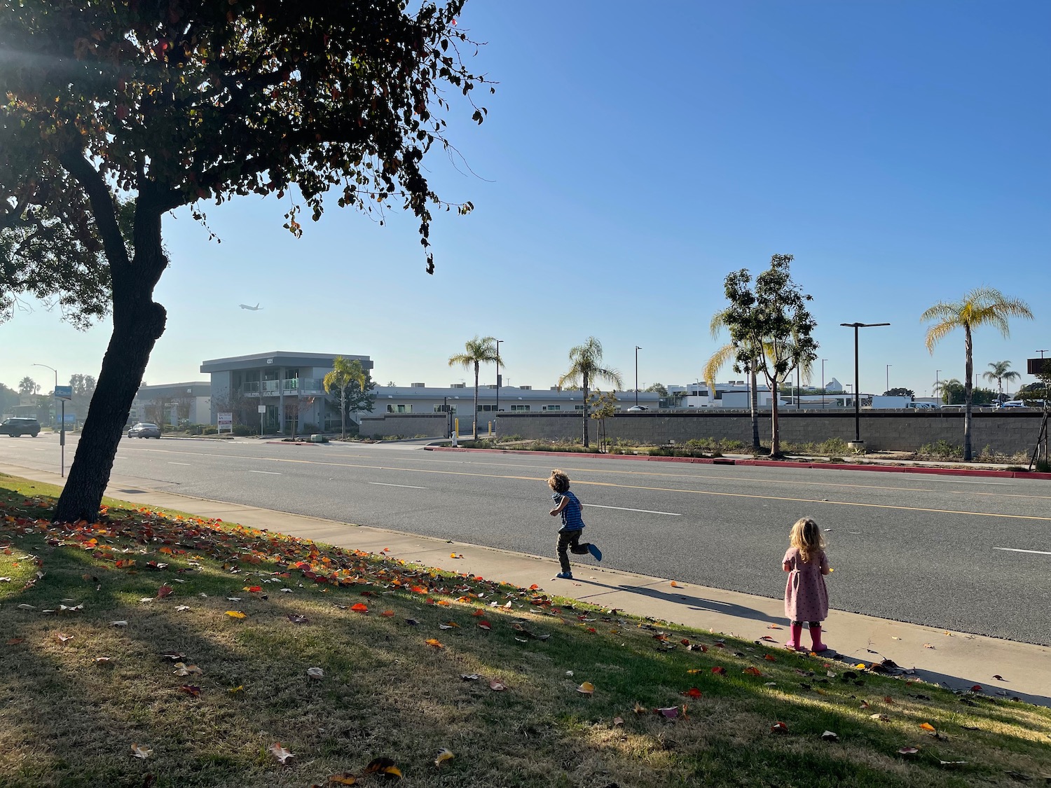 a two children walking on a sidewalk