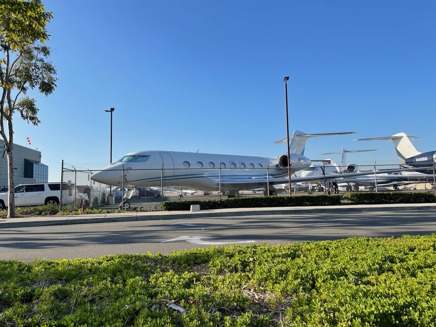 a white airplane parked in front of a fence