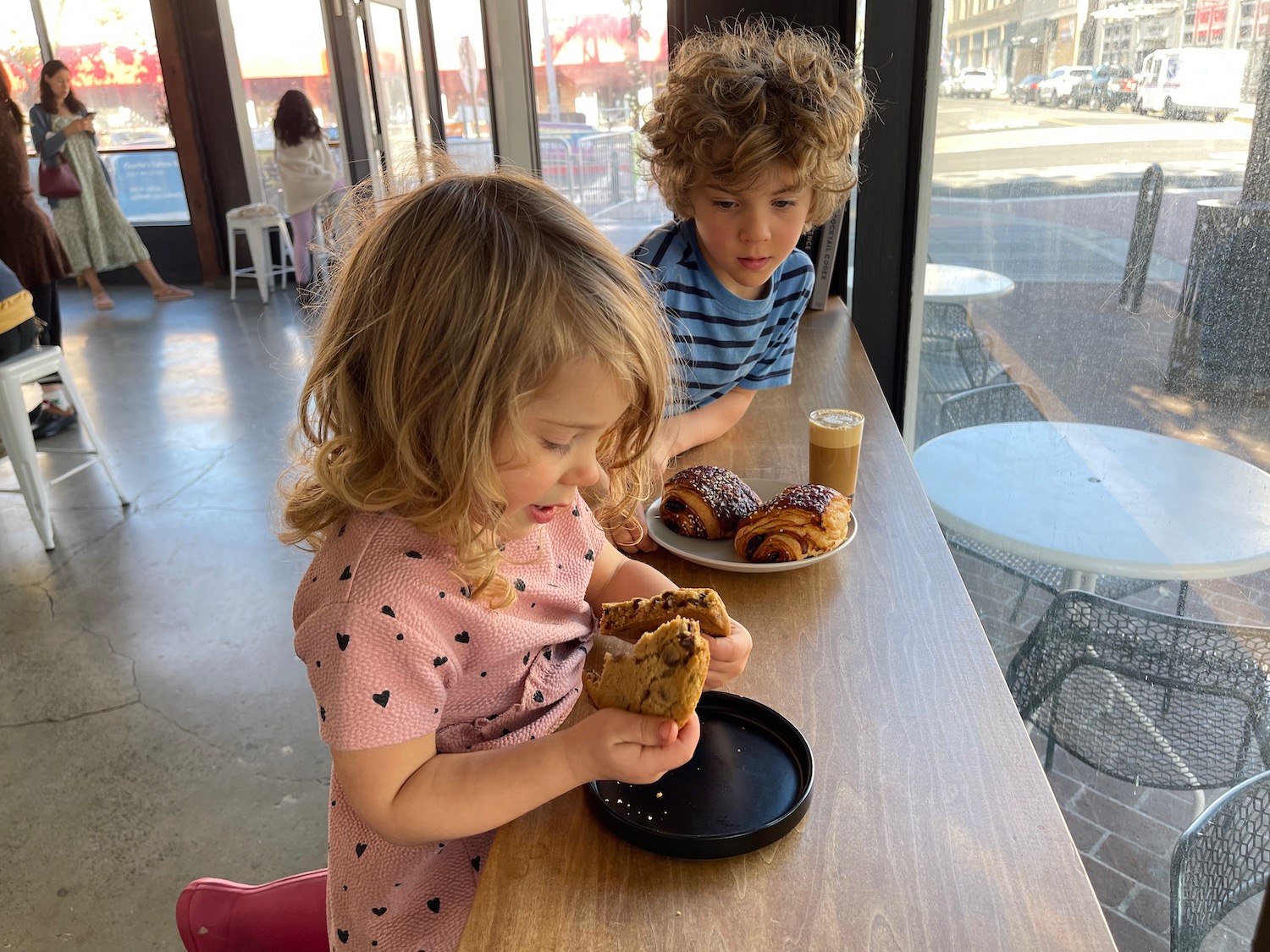 a boy and girl eating food at a table