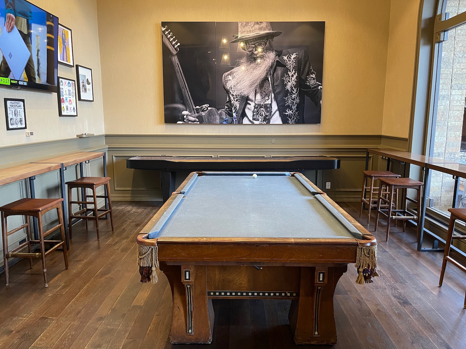 a pool table in a room with a picture on the wall