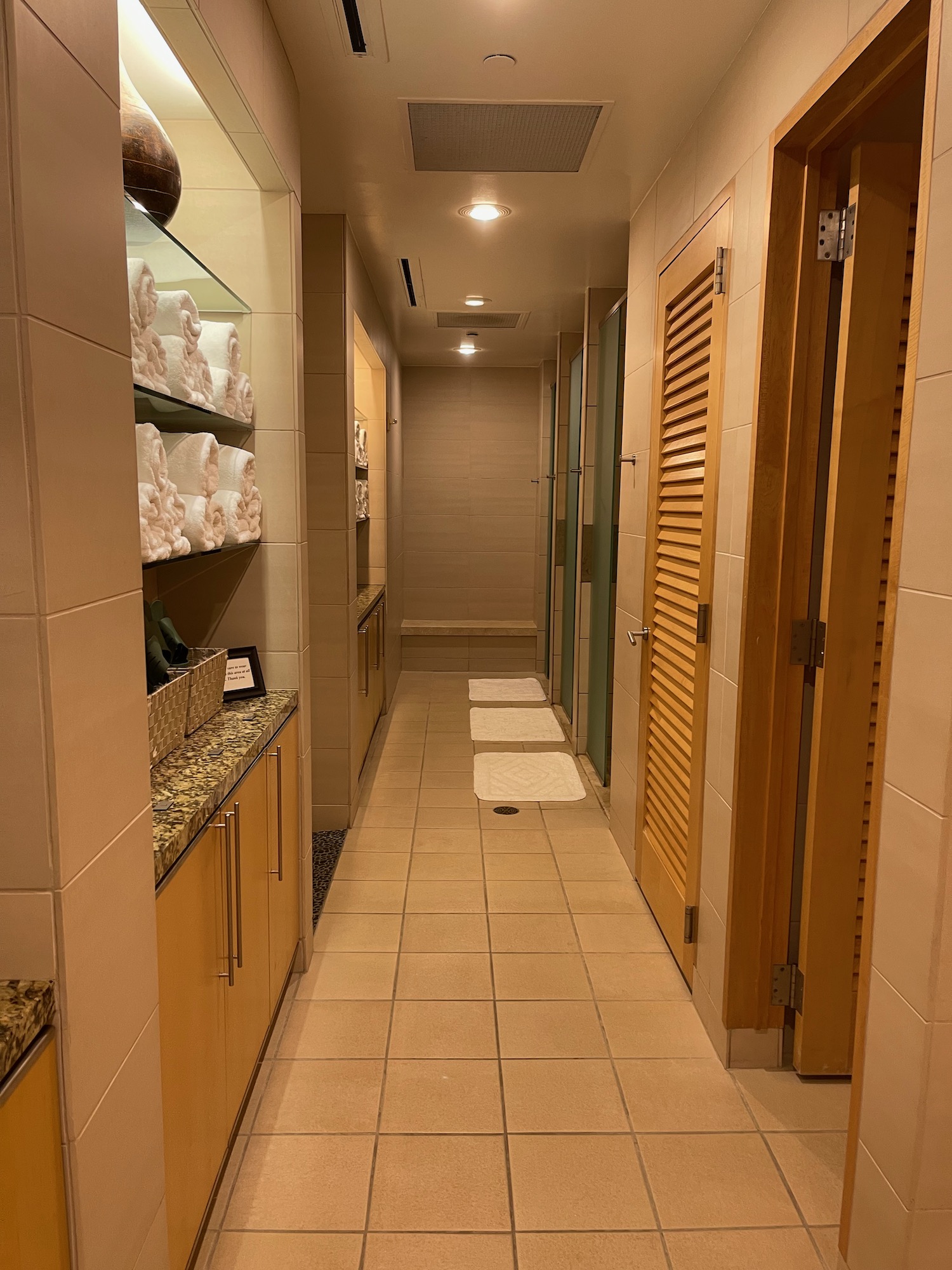 a bathroom with a row of shelves and towels