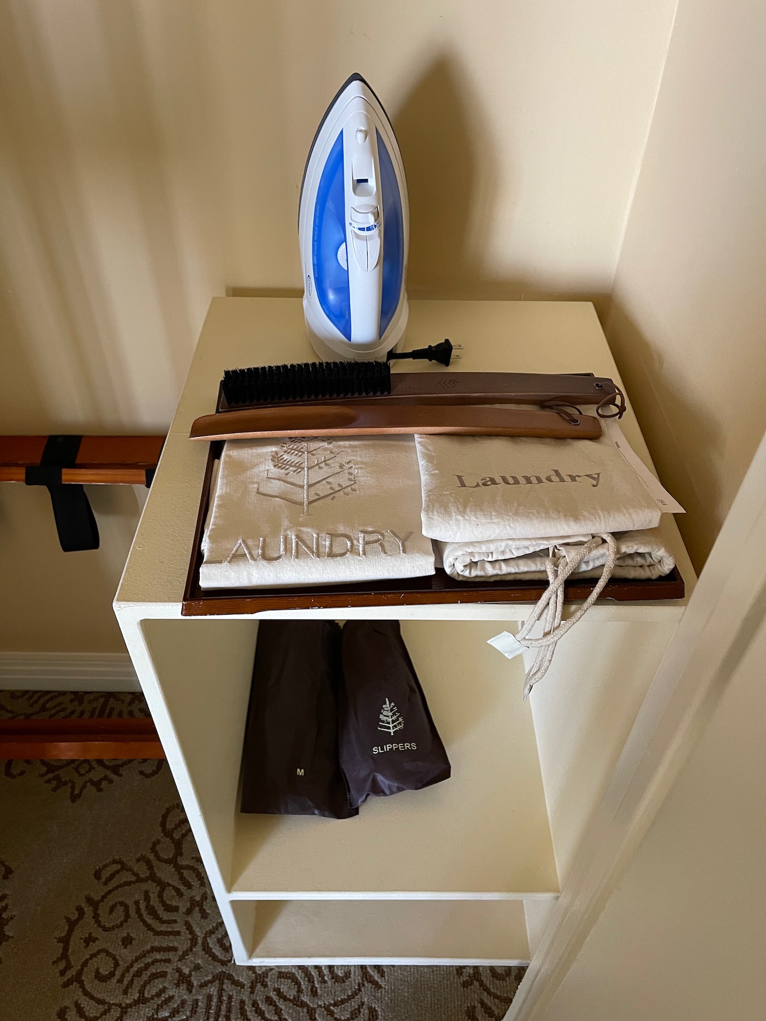 a iron and towels on a shelf