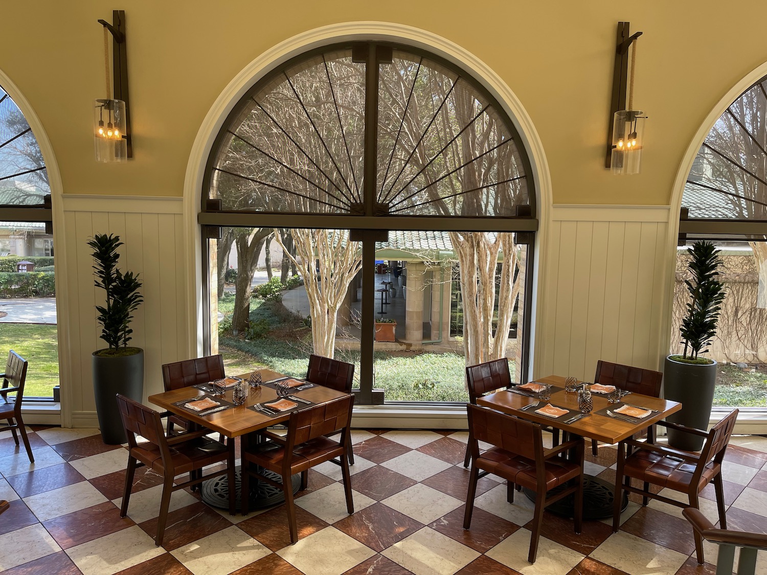 a room with a checkered floor and a large arched window