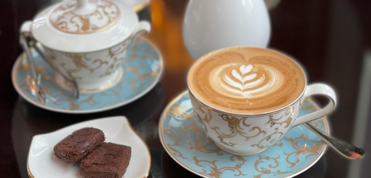 a cup of coffee and brownies on a table