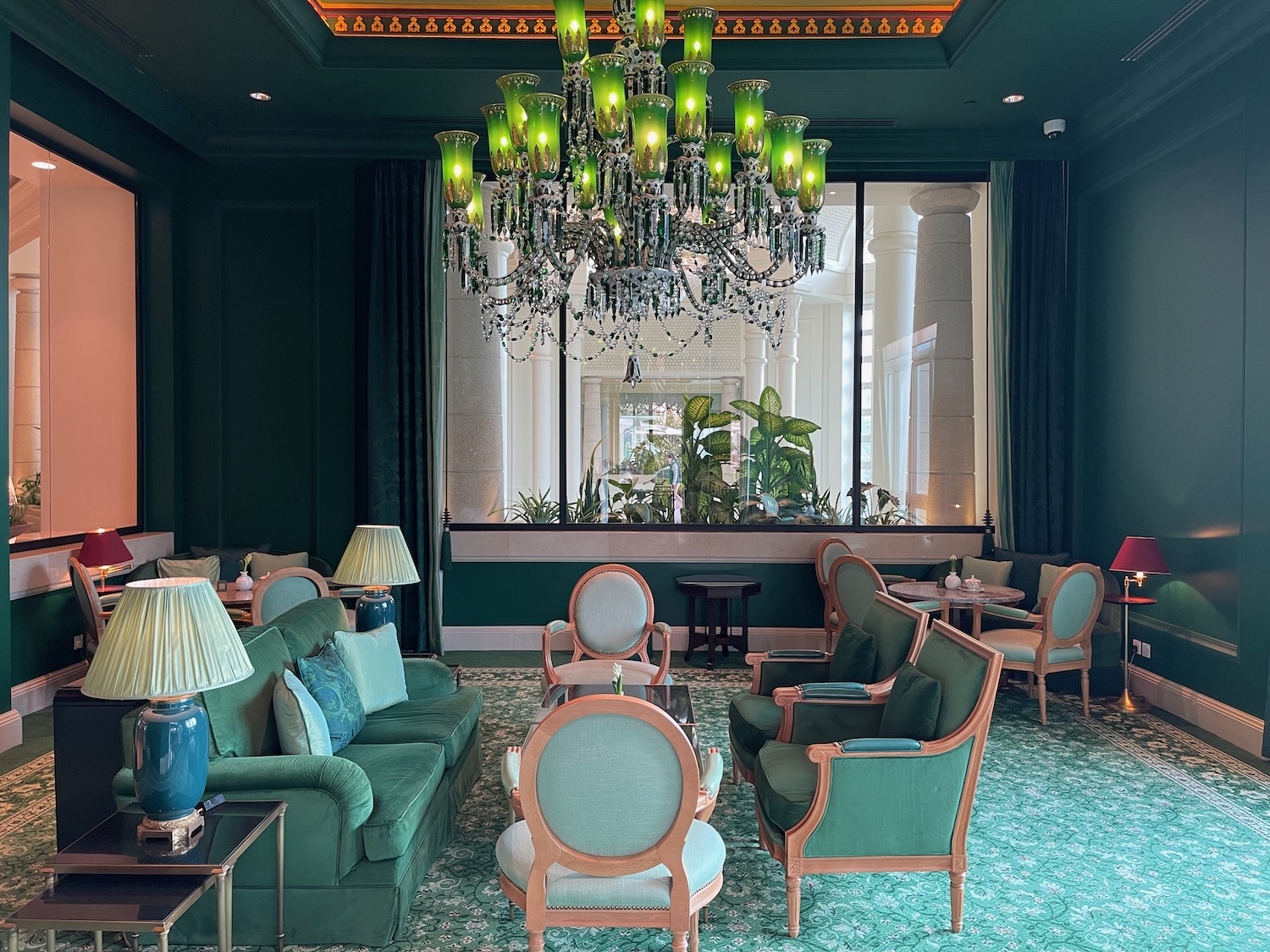 a room with green furniture and a chandelier