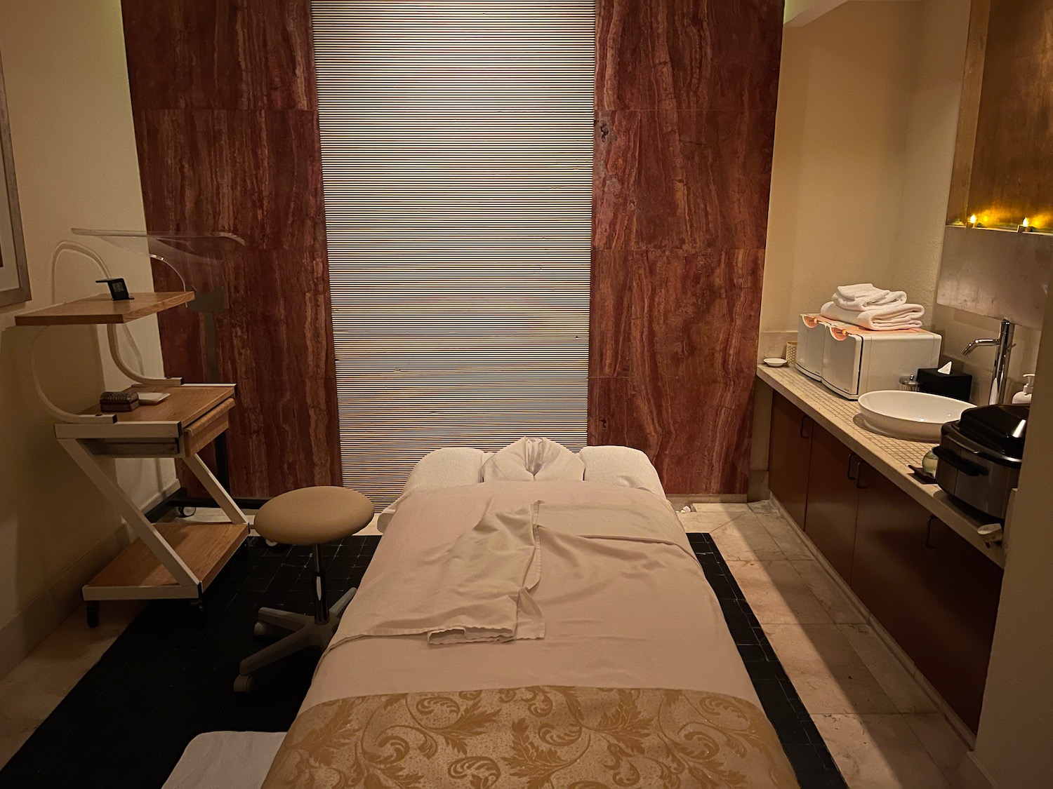 a massage room with a bed and a sink