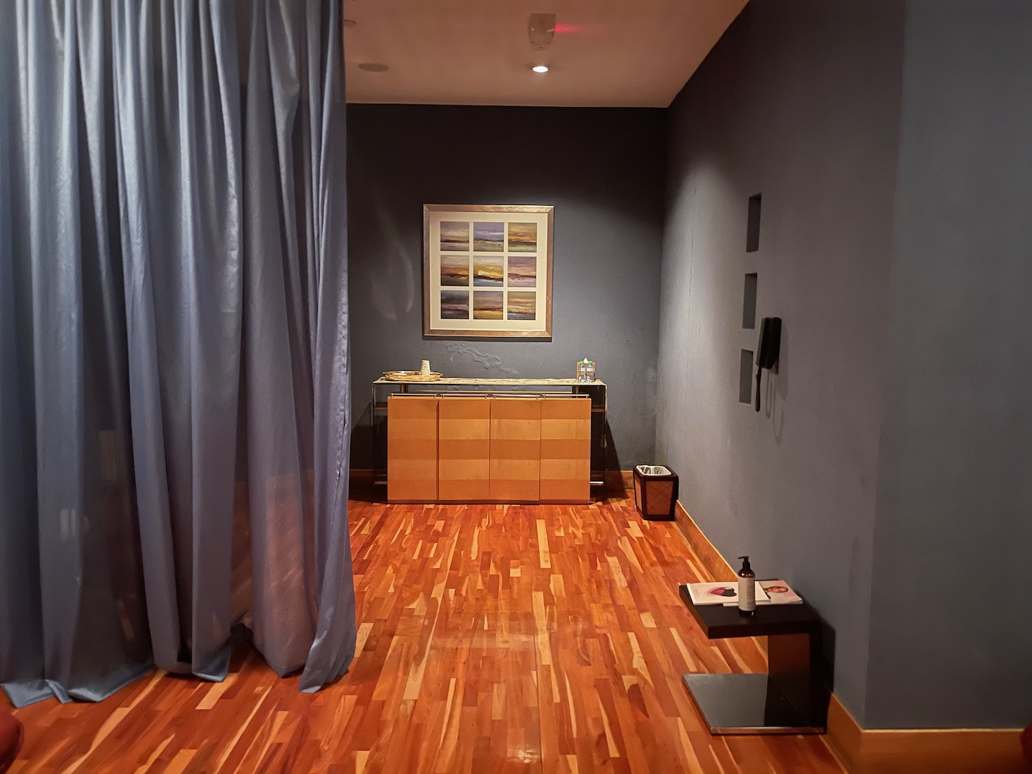 a room with a wood floor and blue curtains