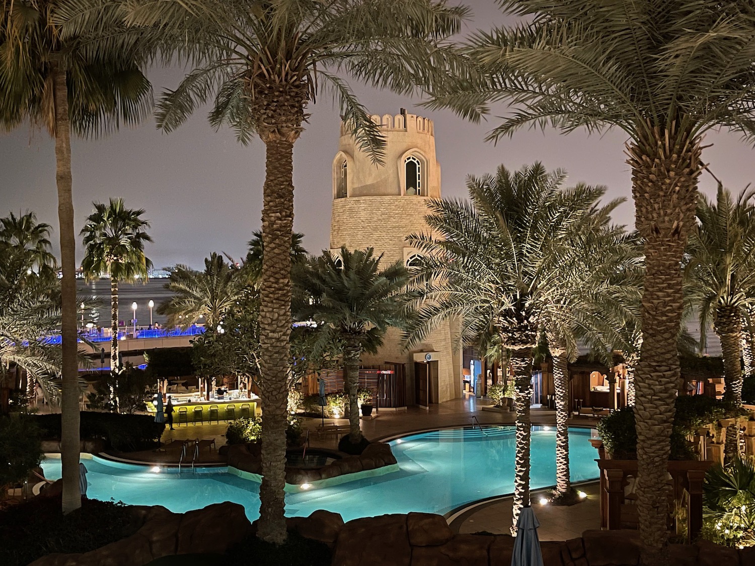 a pool with palm trees and a tower