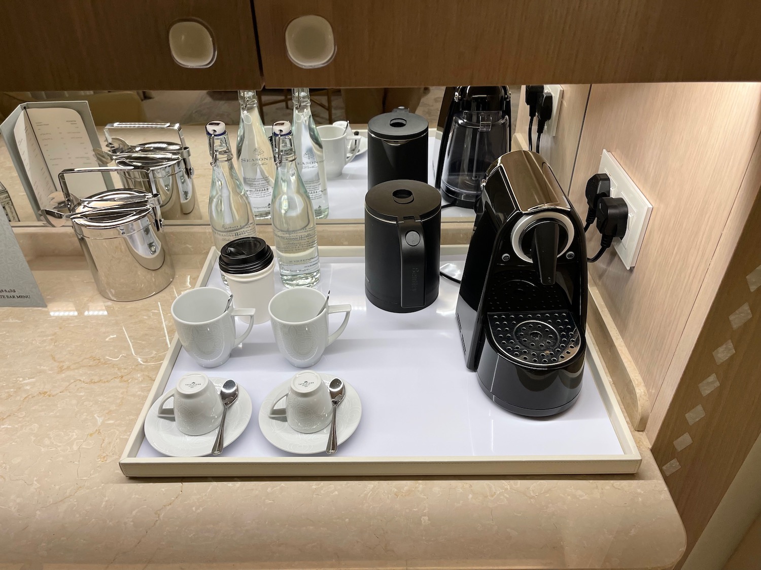 a tray with coffee maker and cups on it