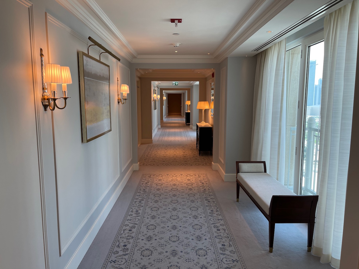 a hallway with a bench and lamps