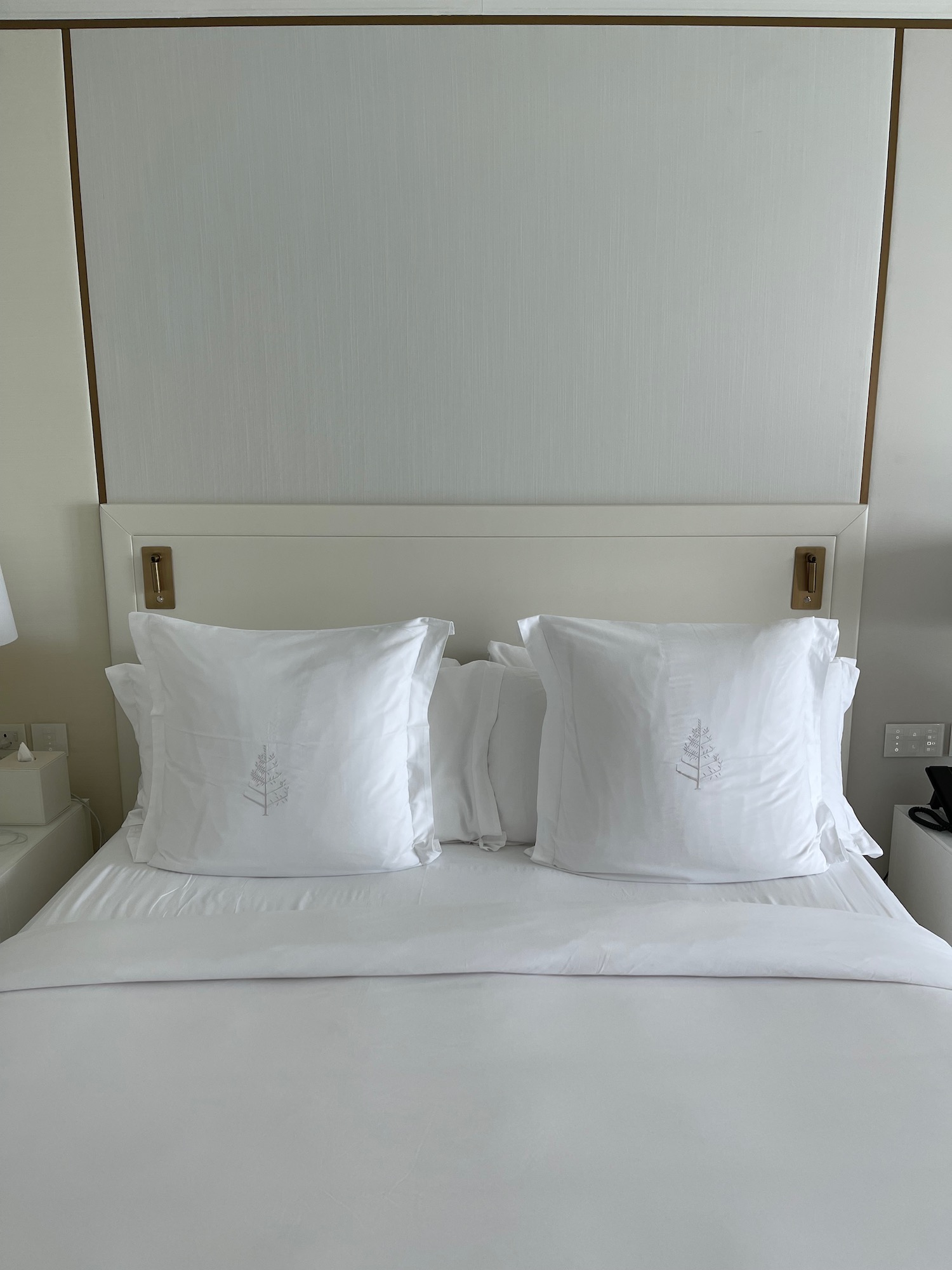 a bed with white pillows and a lamp