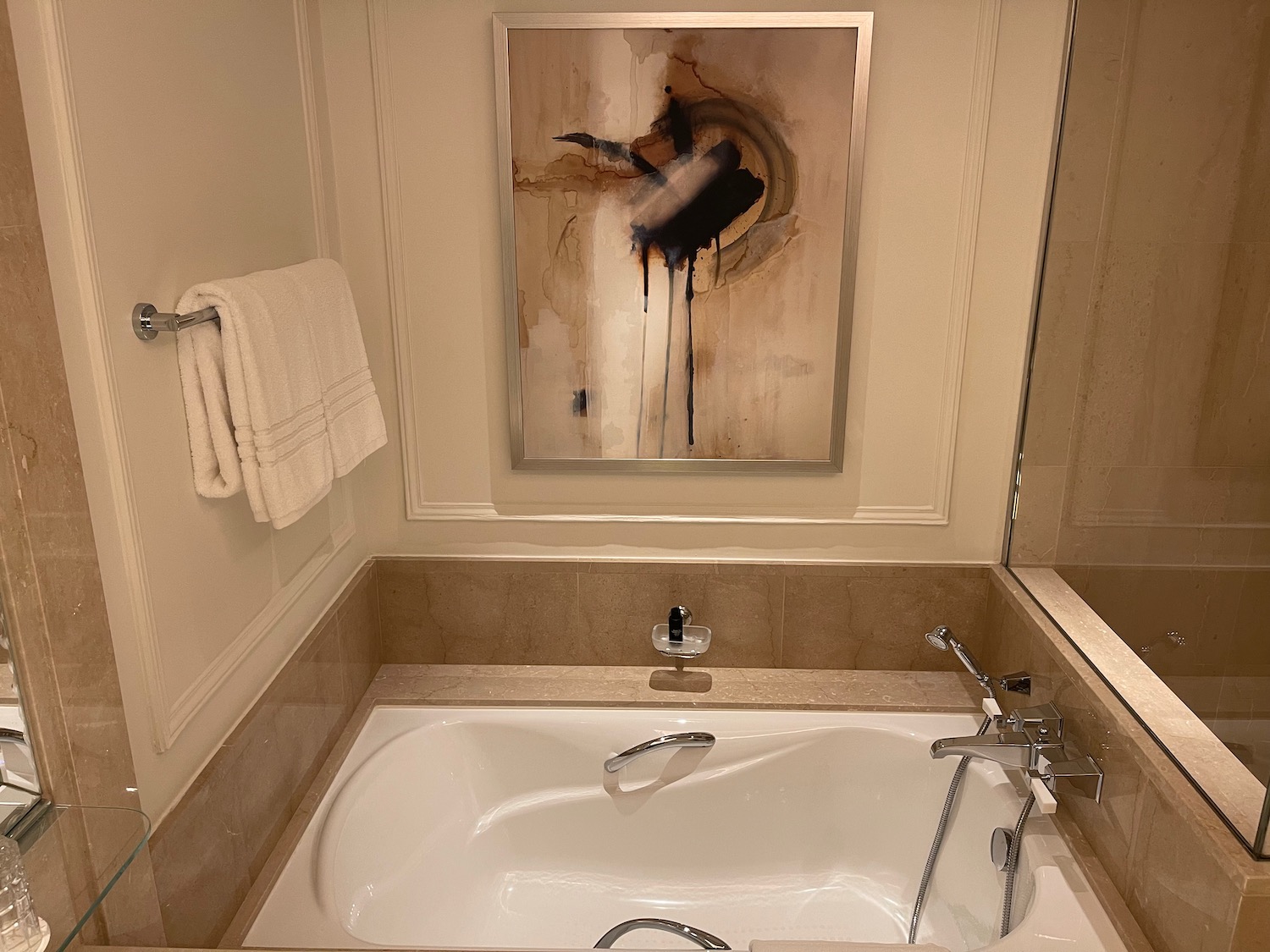 a bathroom with a bathtub and a painting