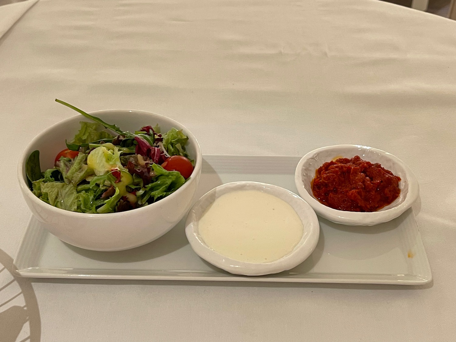 a plate with a bowl of salad and dip