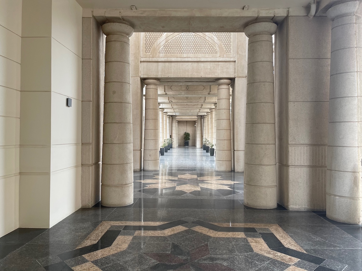 a hallway with columns and a tiled floor