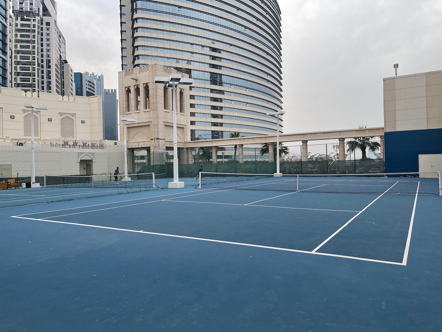 a tennis court with a tall building in the background