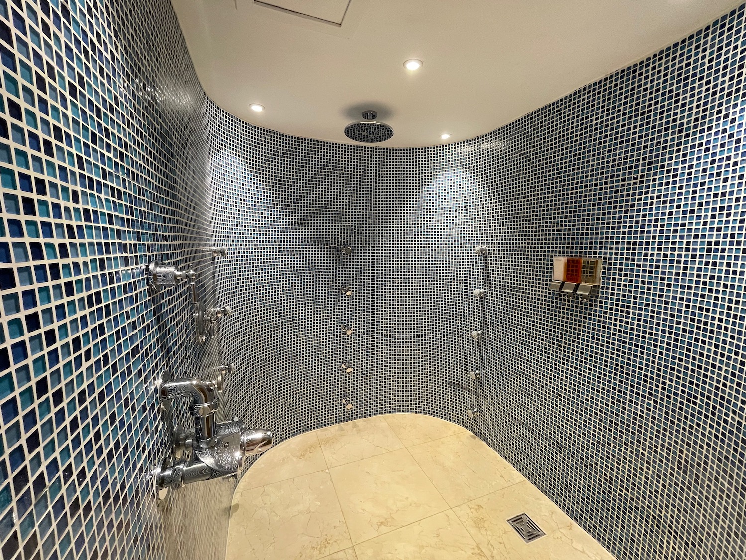 a shower with a tile wall and a shower head