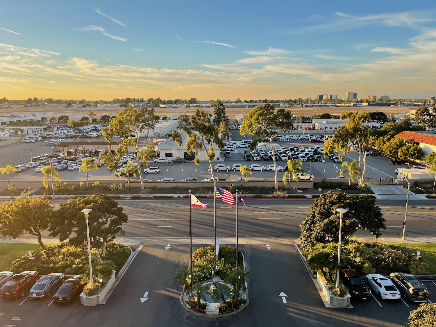 a parking lot with flags and trees