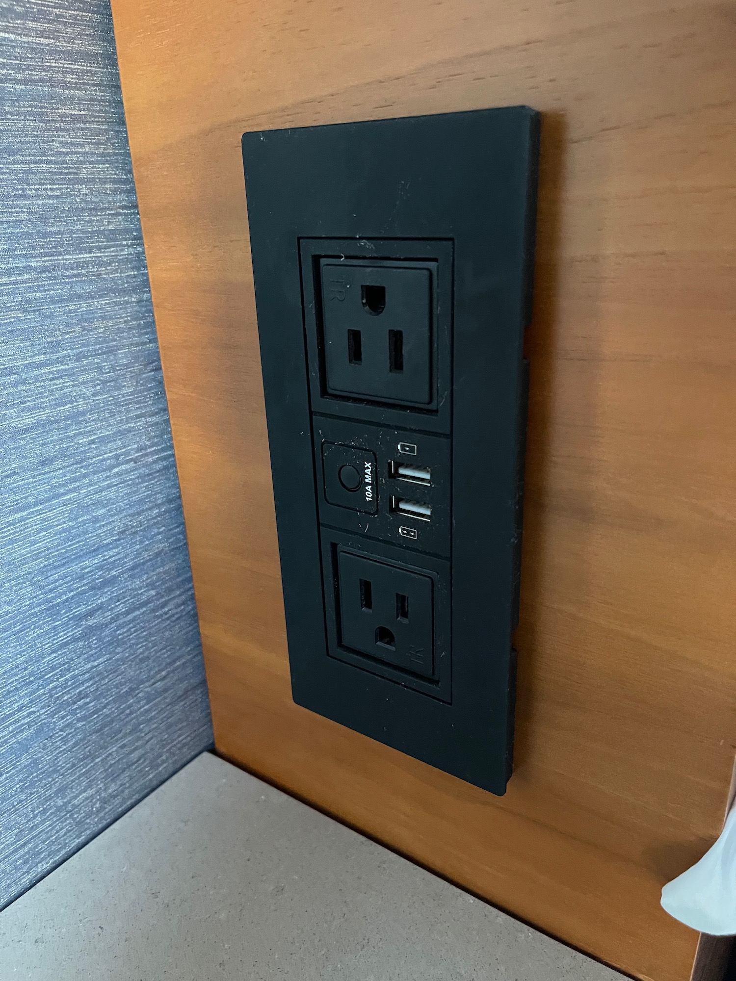 a black electrical outlet on a wood surface