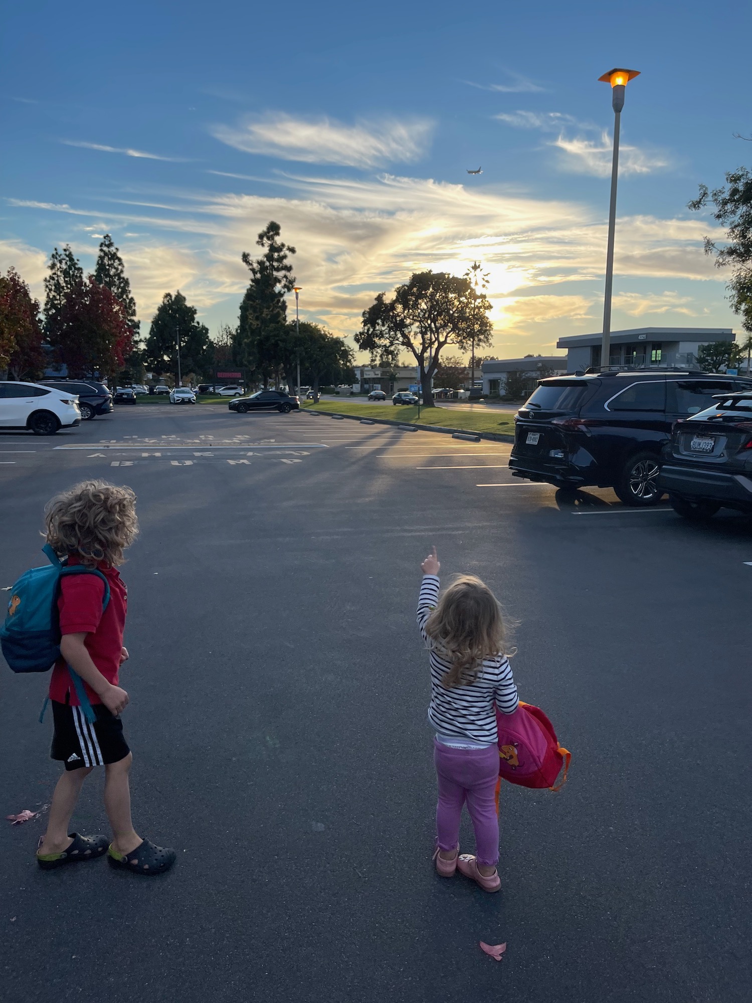 a two children standing in a parking lot