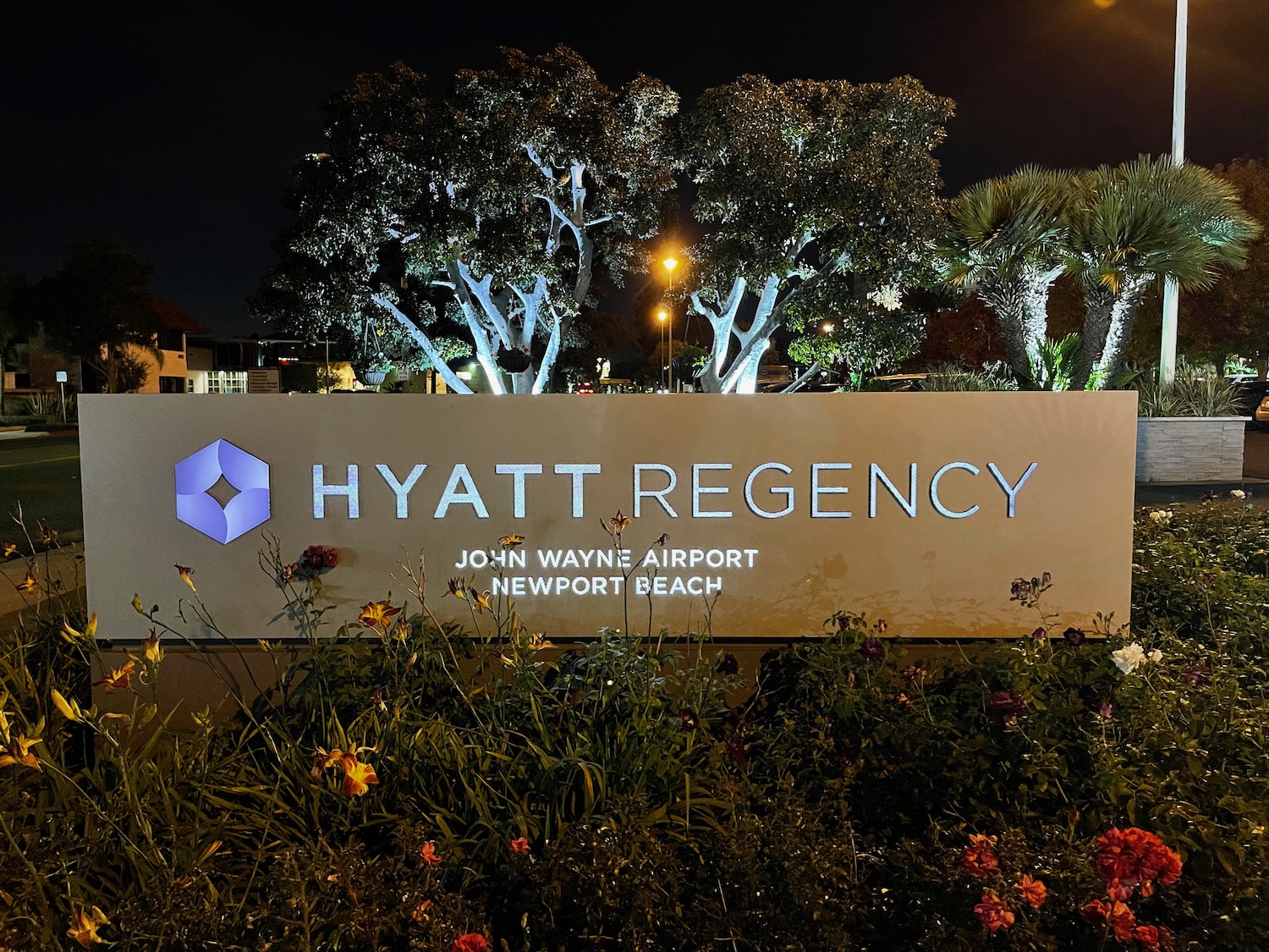 a sign with trees and plants in front of it