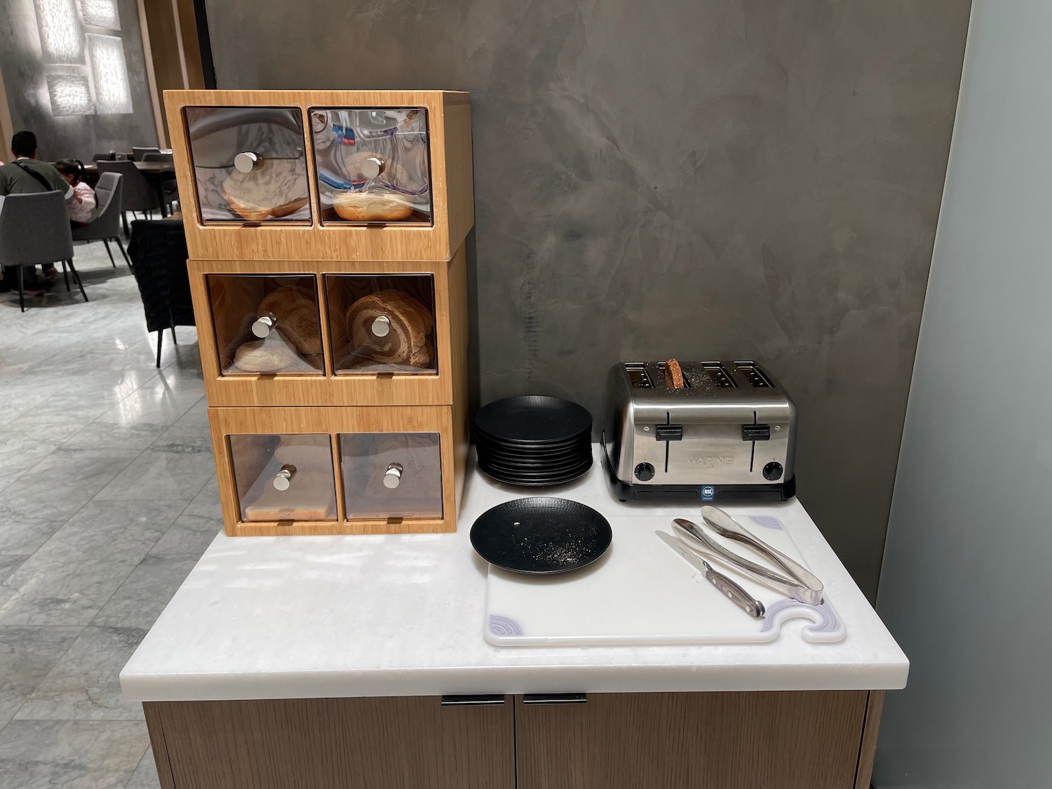 a kitchen counter with a toaster and bread in a case