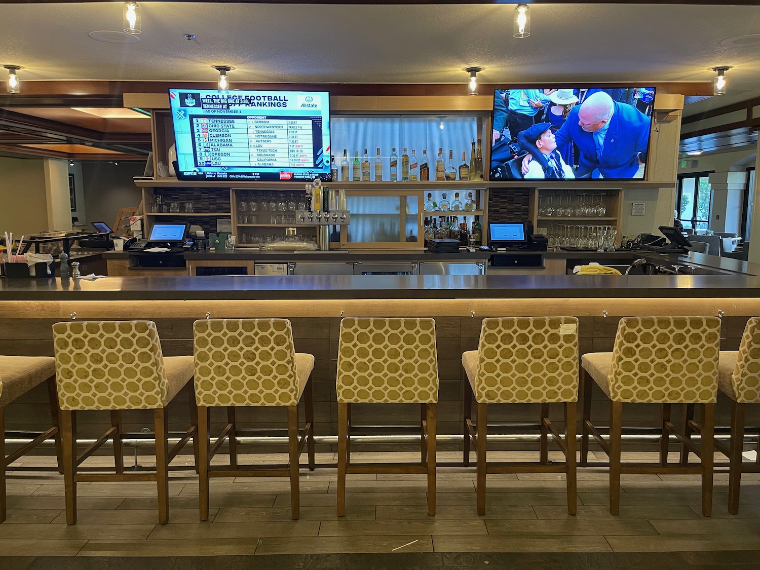 a bar with chairs and televisions