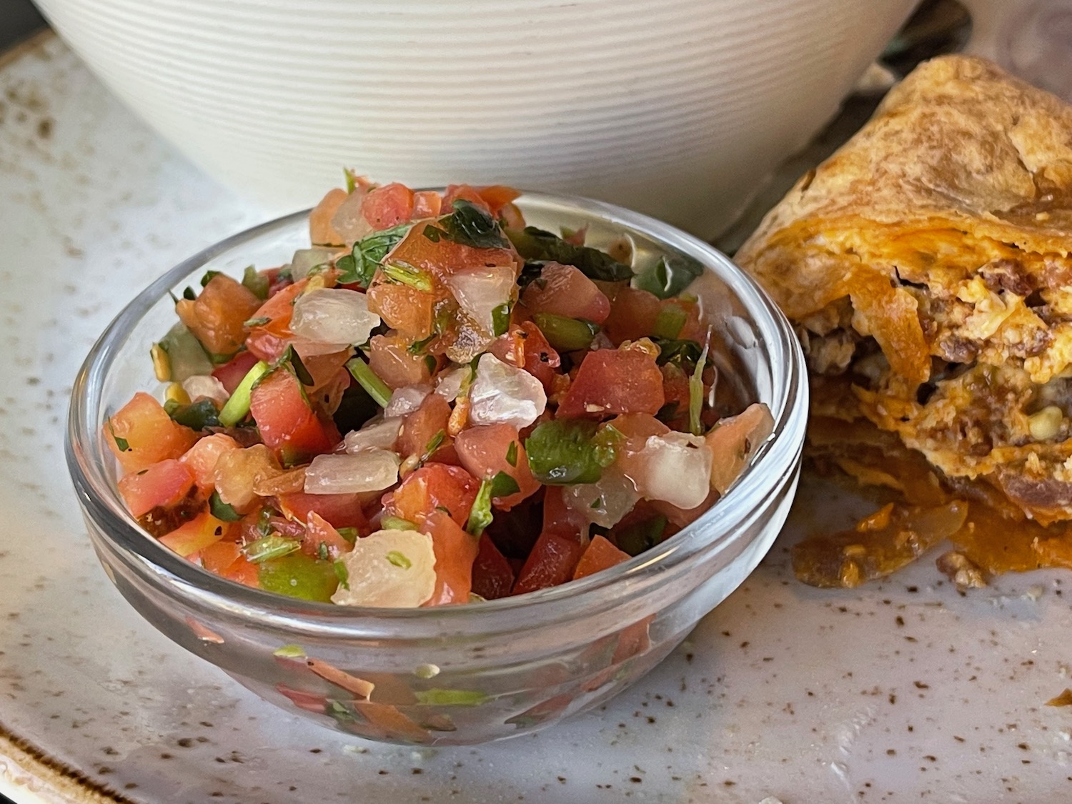 a bowl of salsa and burrito
