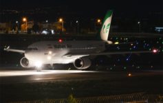 a white airplane on a runway at night