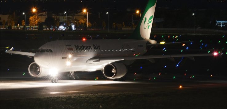 a white airplane on a runway at night