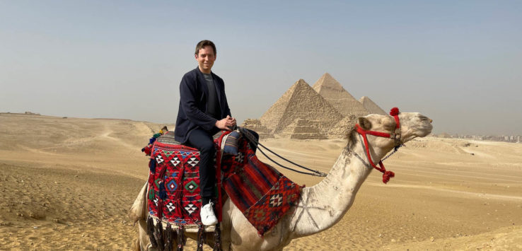 a man riding a camel in the desert