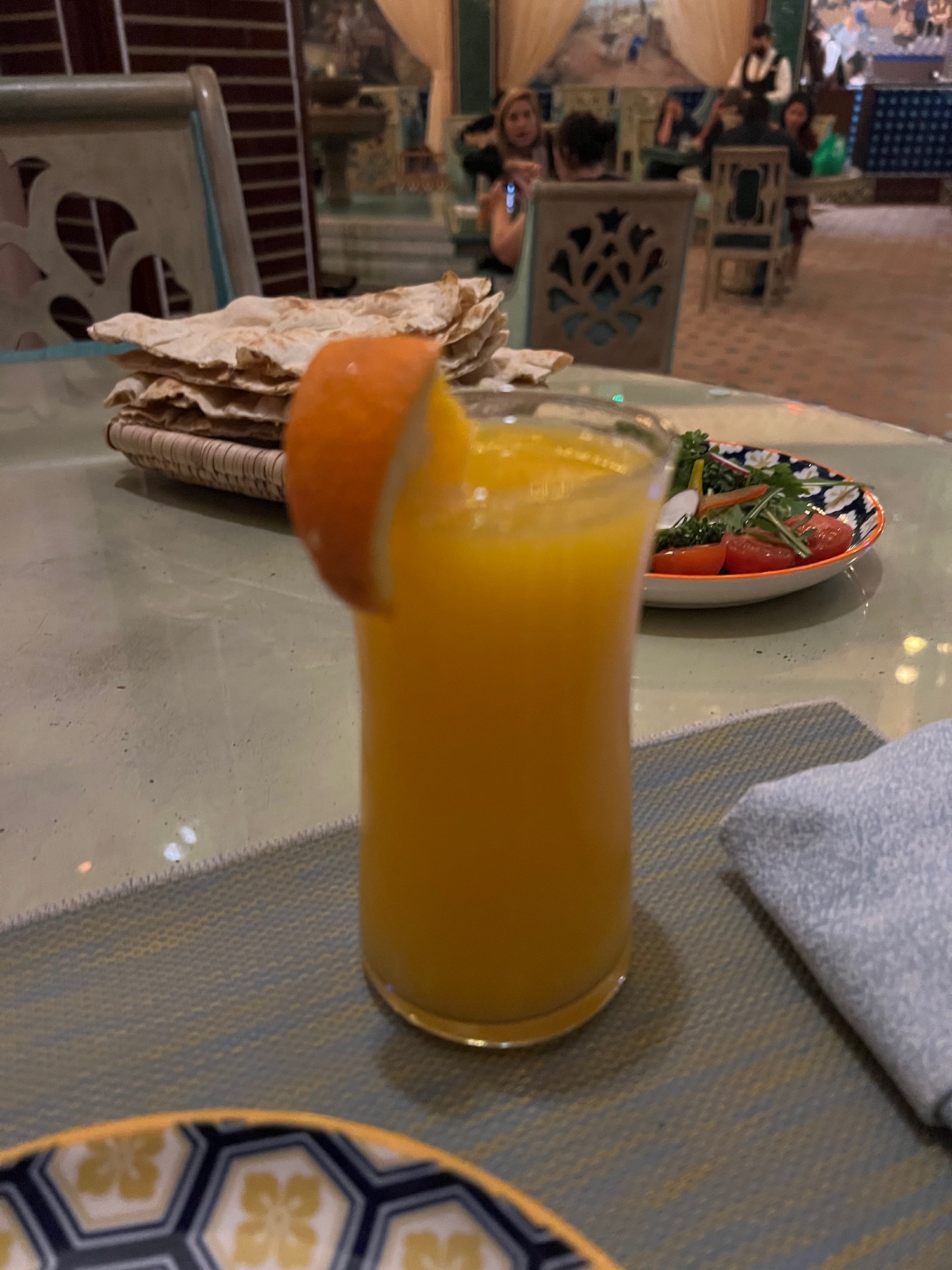 a glass of orange juice with a slice of orange on top of it