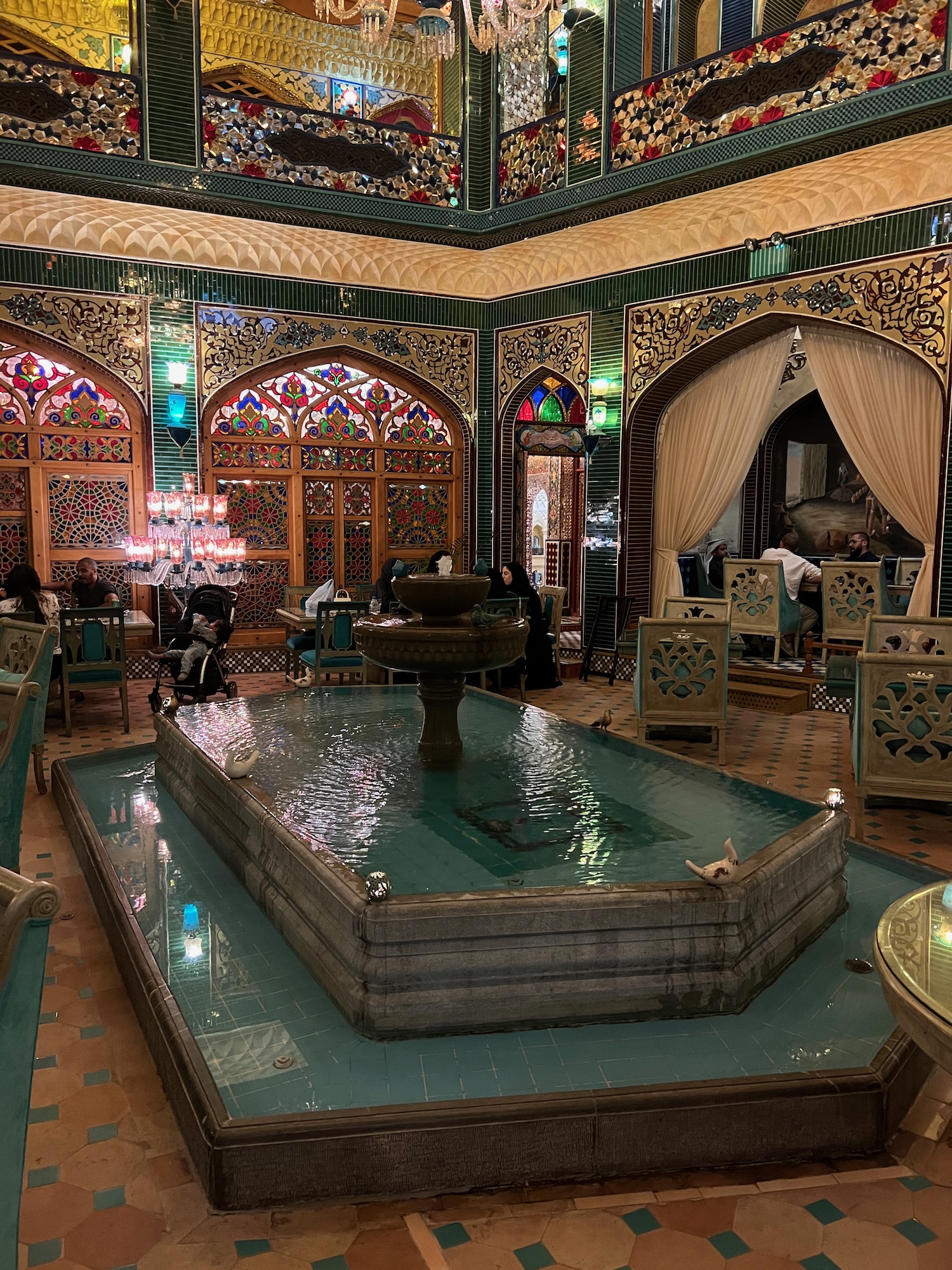 a room with a fountain and tables and chairs