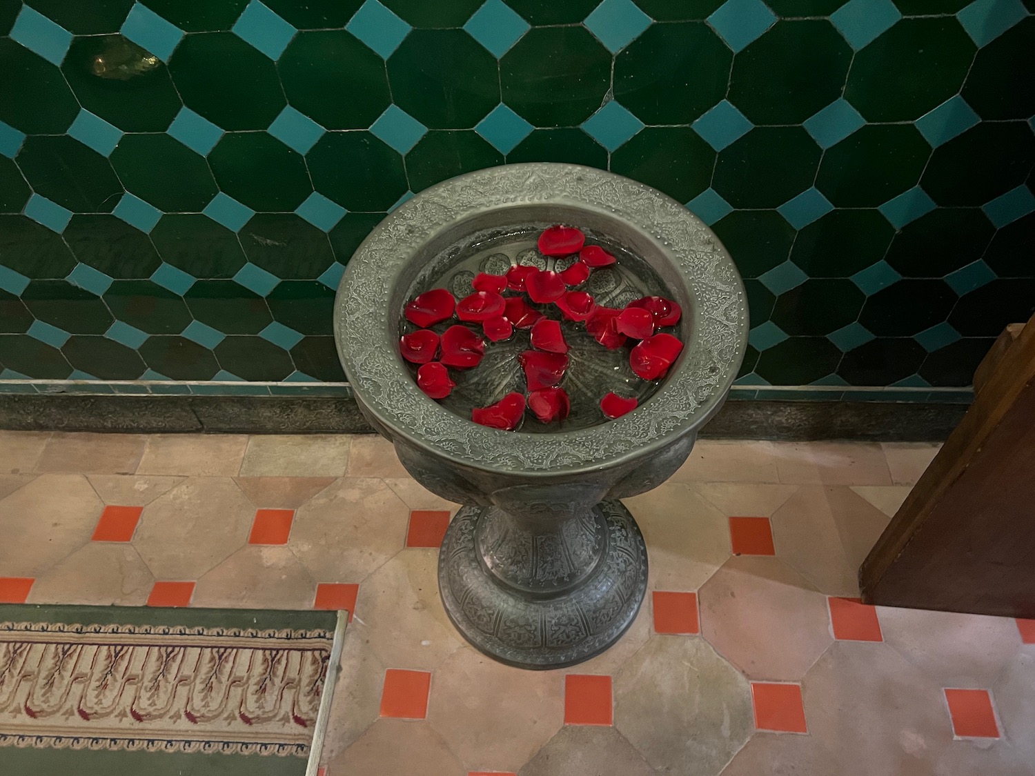 a bowl of water with red petals