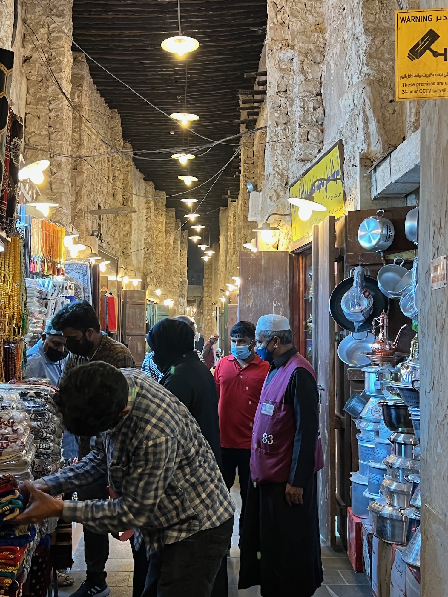 people in a market with many people wearing masks