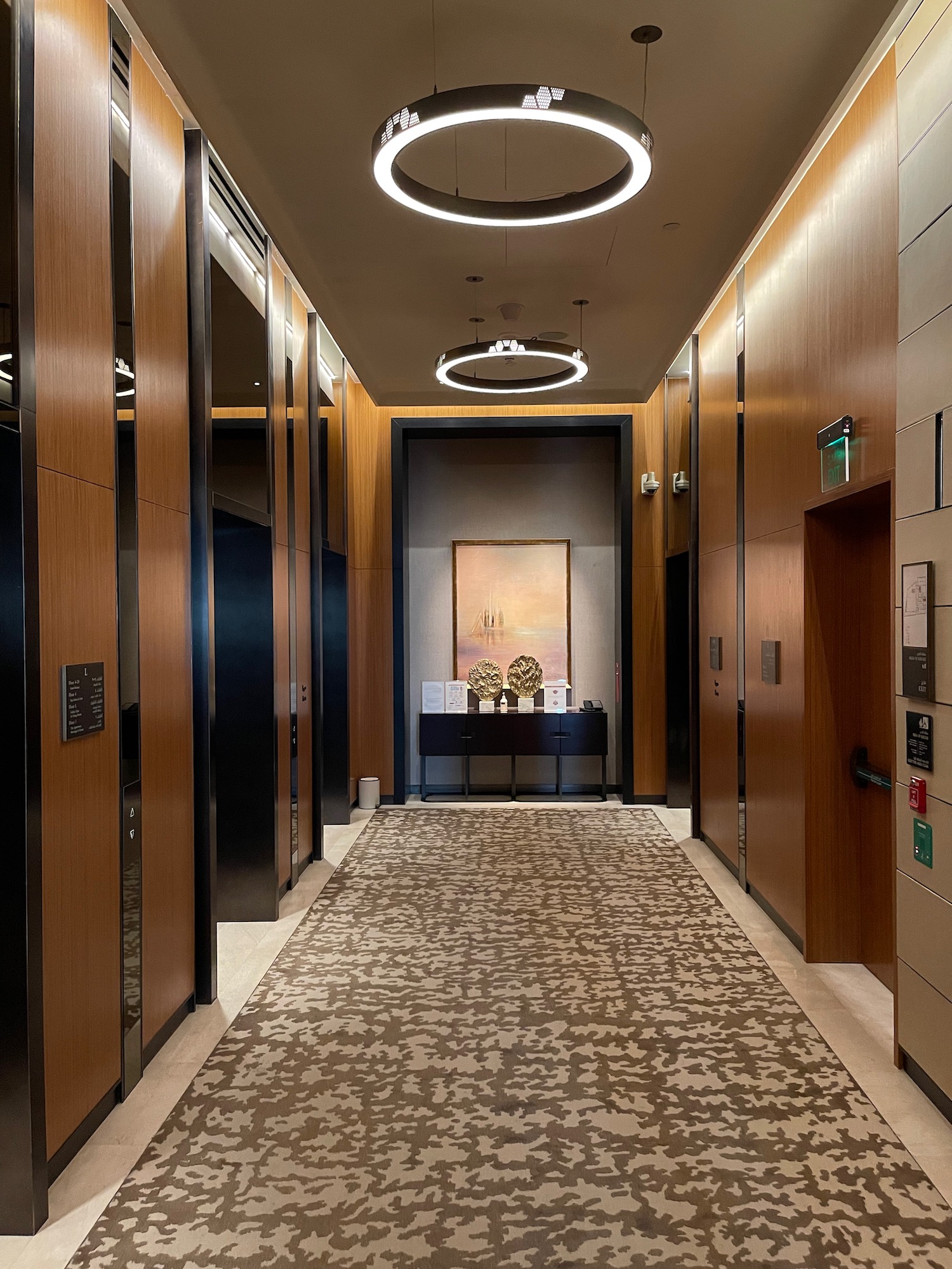 a hallway with a rug and a painting on the ceiling