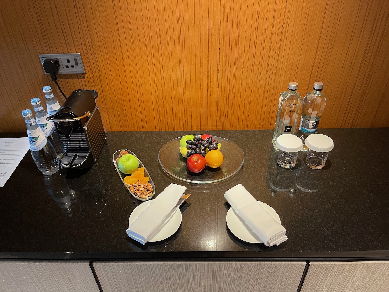 a plate of fruit and a glass of water on a counter