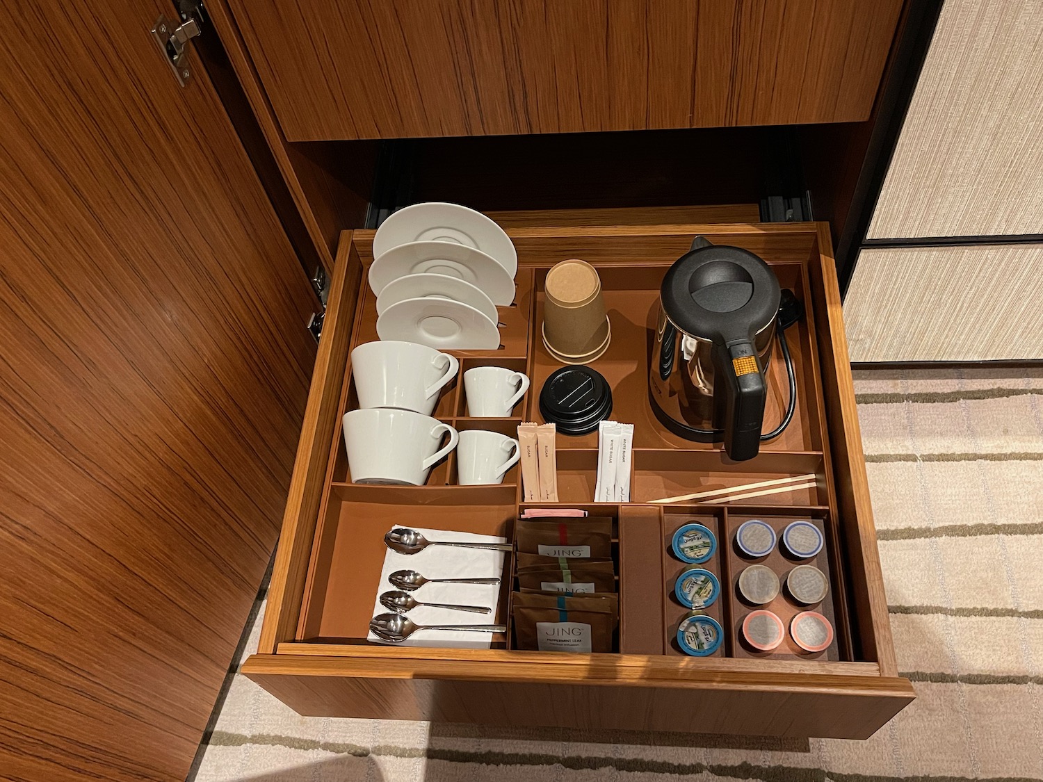 a drawer with a coffee pot and cups