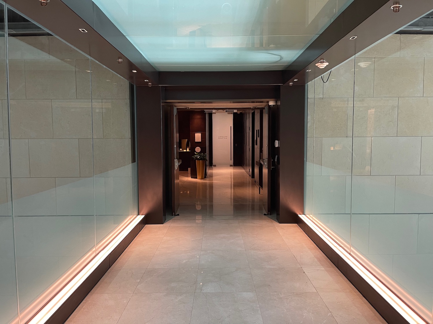 a hallway with glass walls and a light on the ceiling