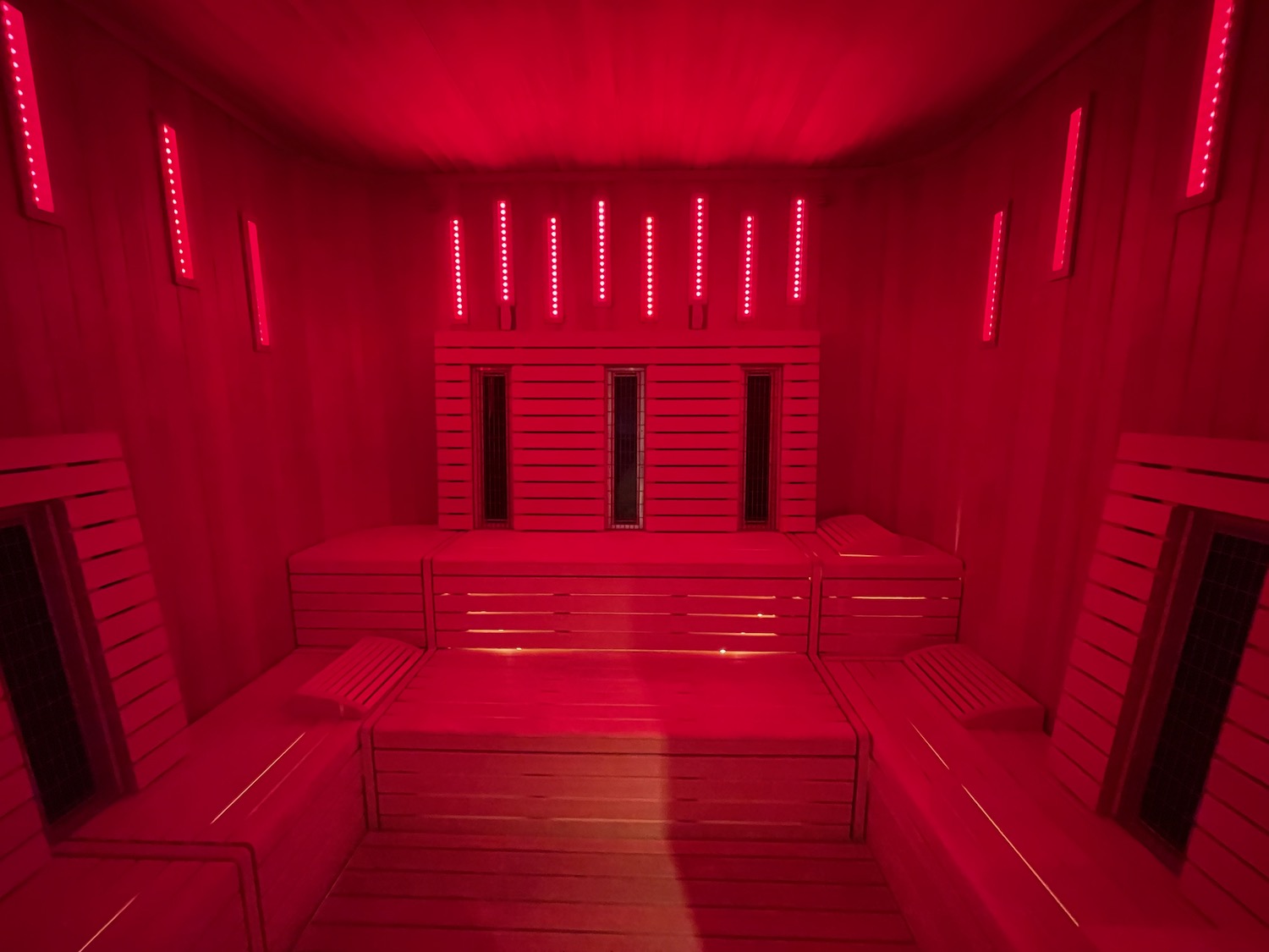 a red room with wooden benches and lights