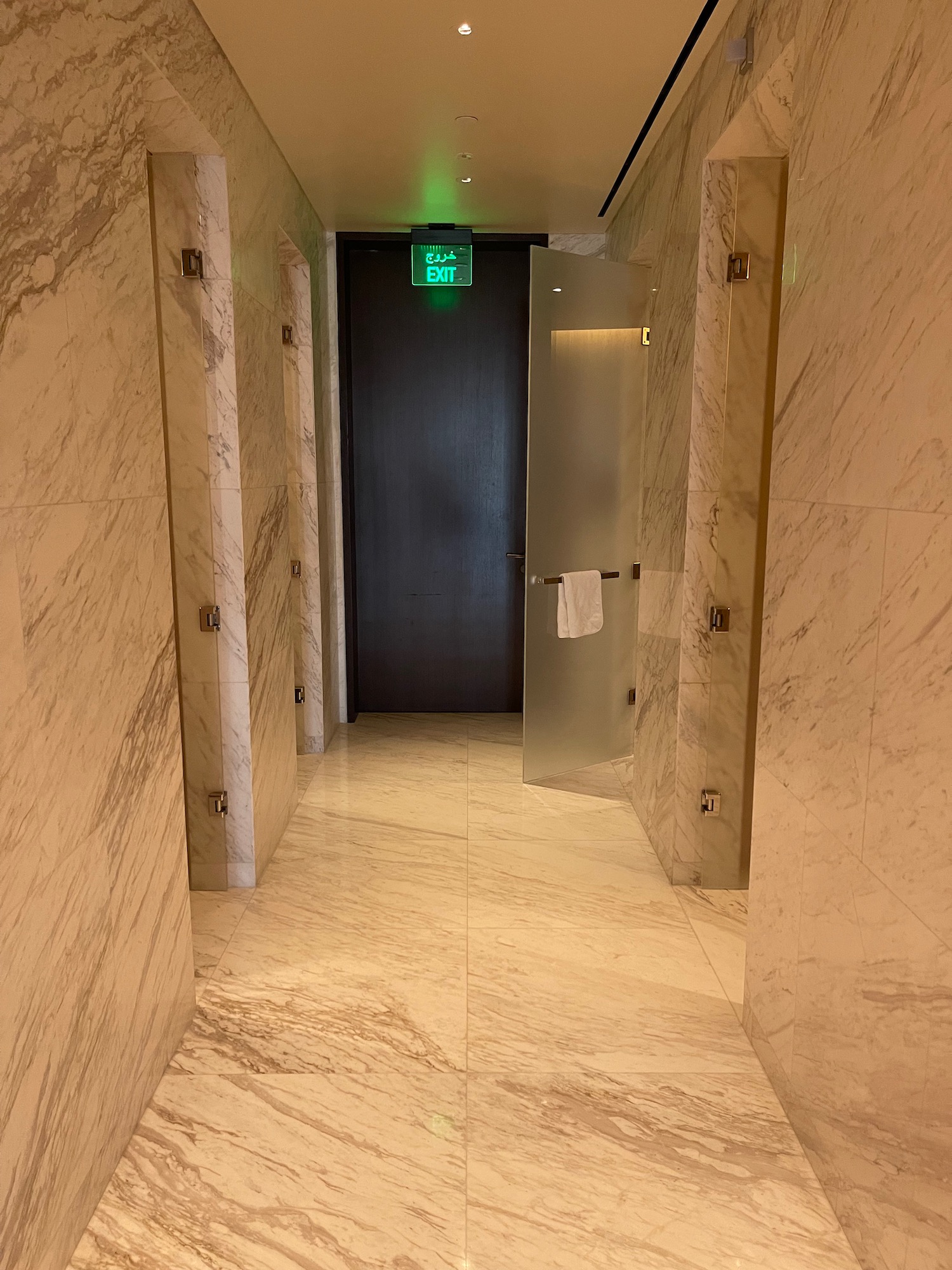 a hallway with a door and a green sign