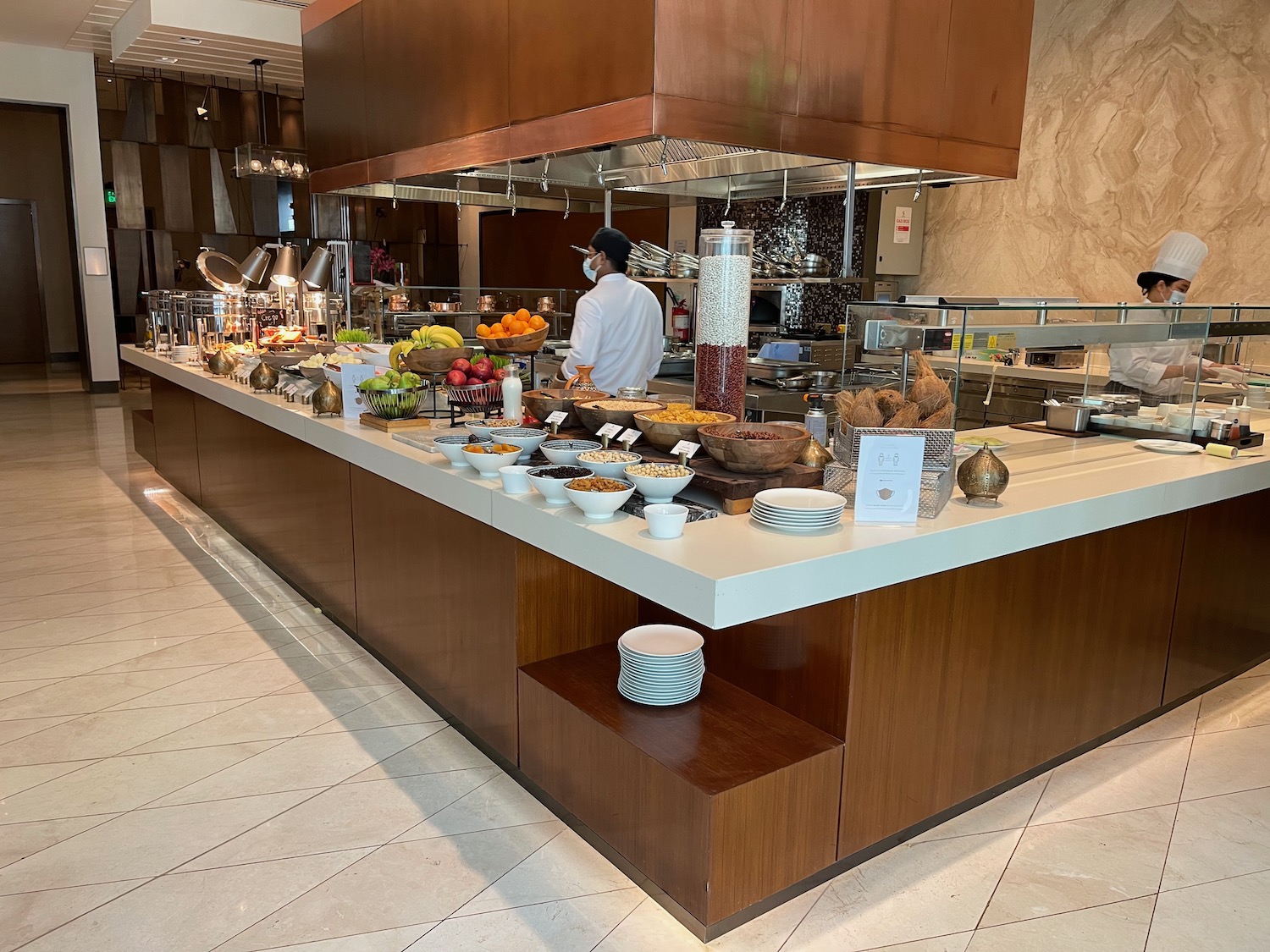 a man standing behind a counter with food on it