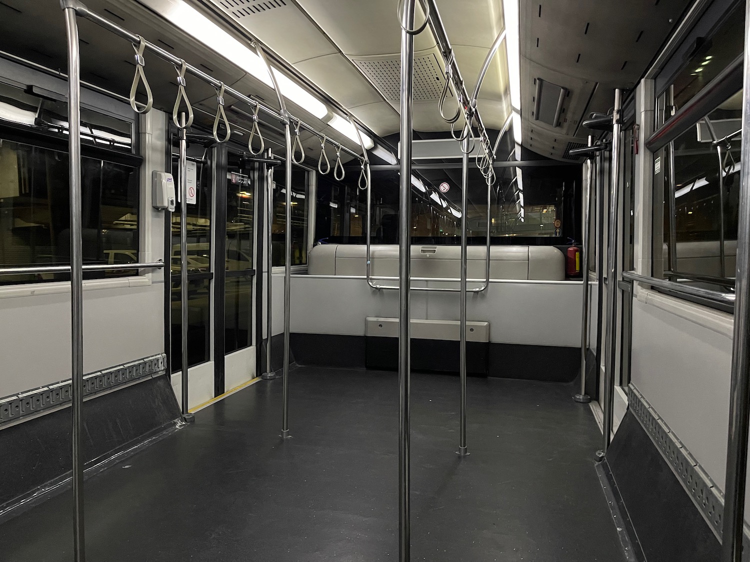 a interior of a bus with handles on the ceiling