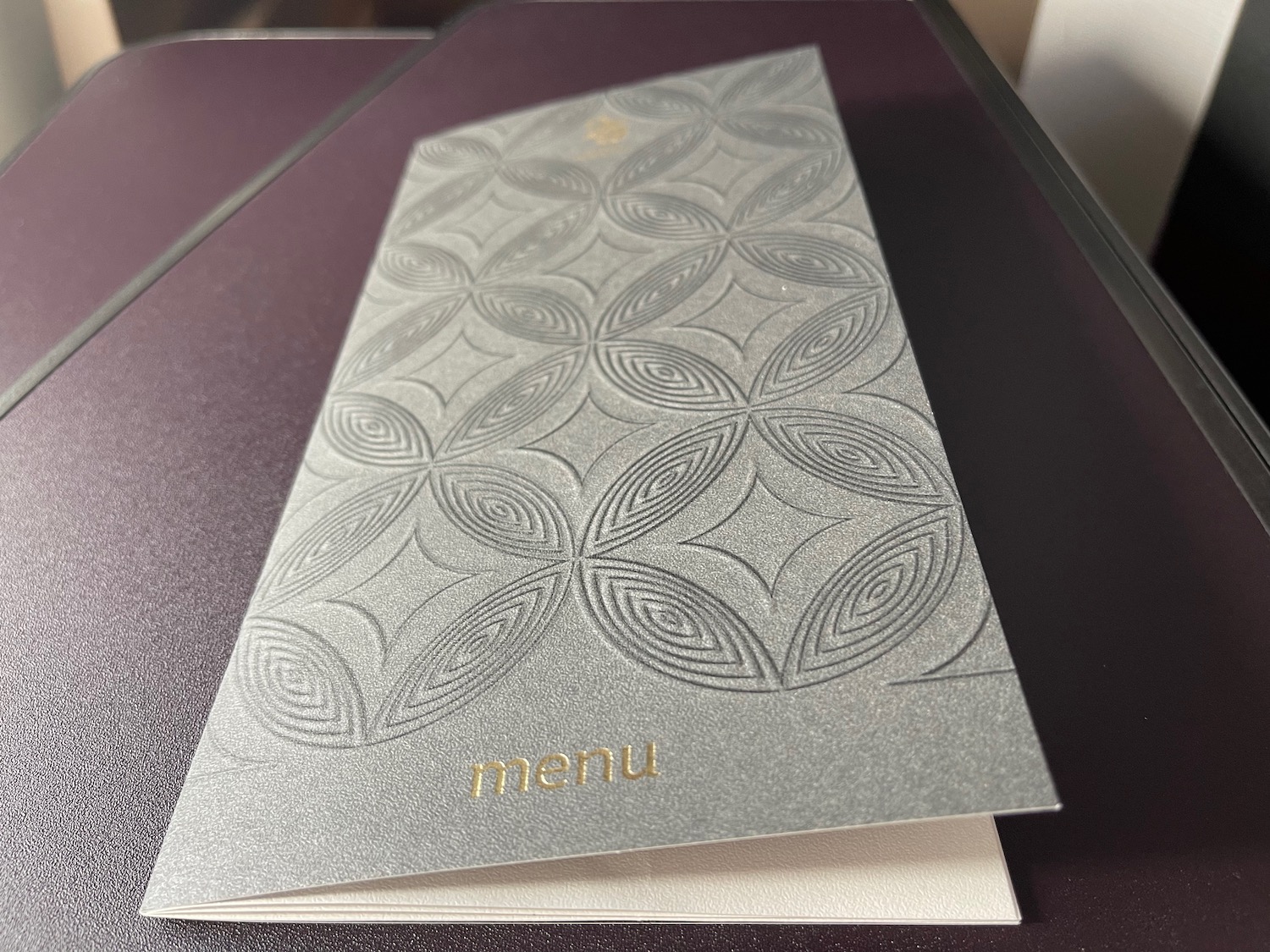 a silver menu on a purple surface