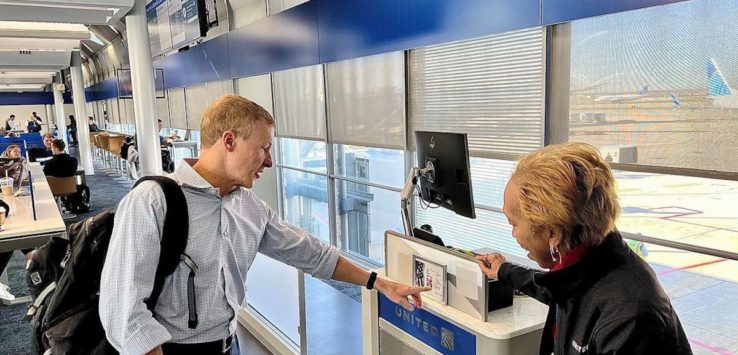 a man and woman standing in front of a computer