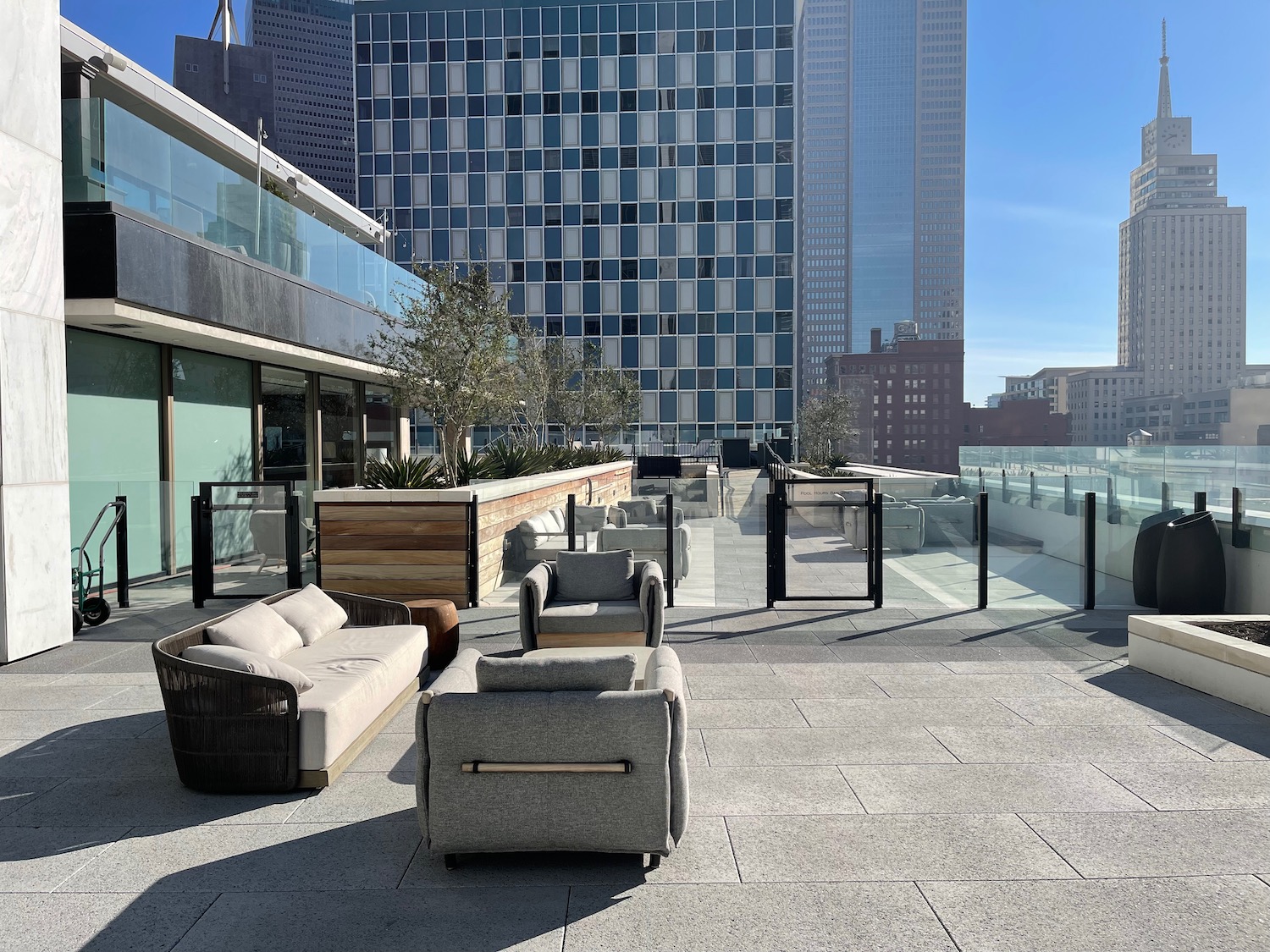 a rooftop patio with a group of couches and a glass balcony