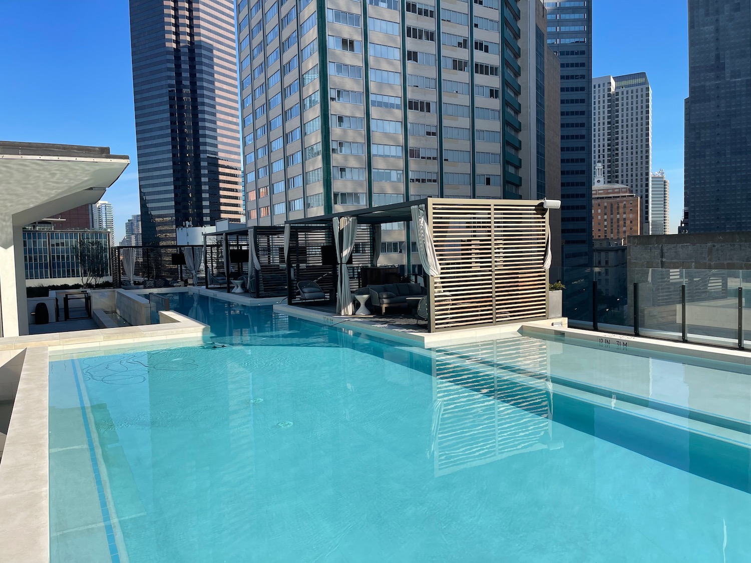 a pool with a roof over it and a building in the background