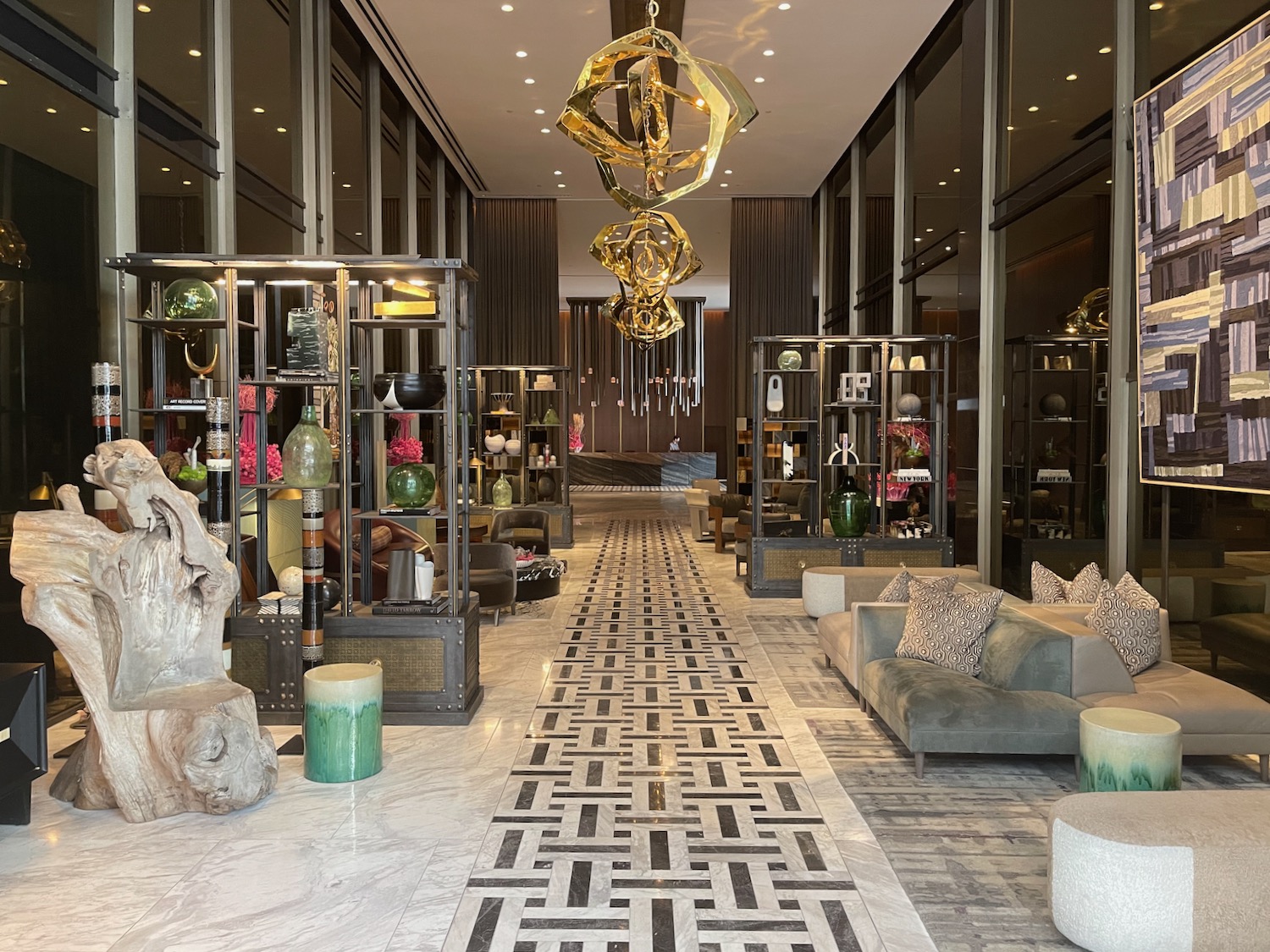 a lobby with a large chandelier and shelves