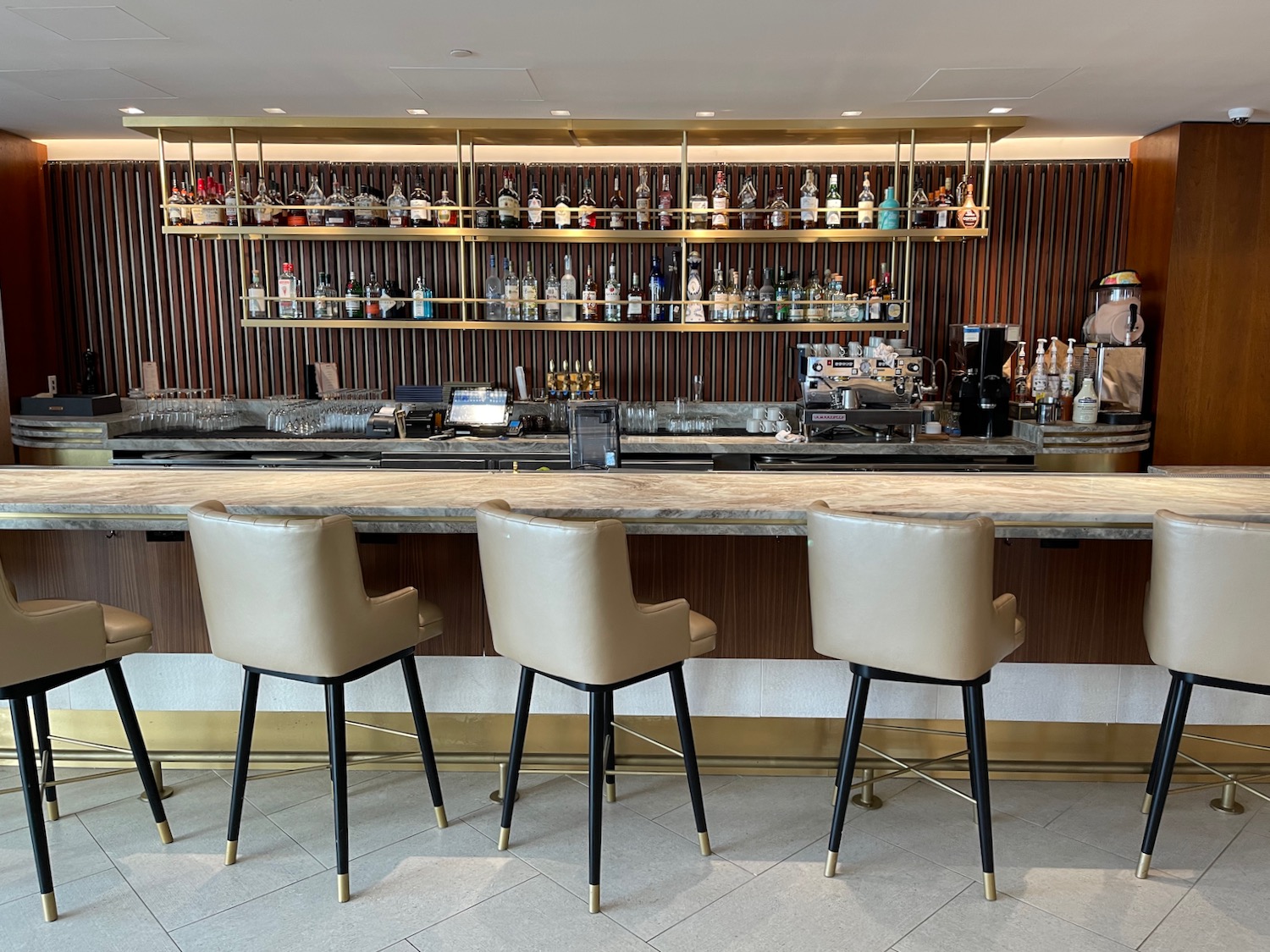 a bar with chairs and shelves of liquor